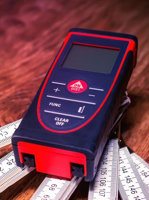Technicien en gants utilisant un appareil de mesure électrique sur un tableau de contrôle