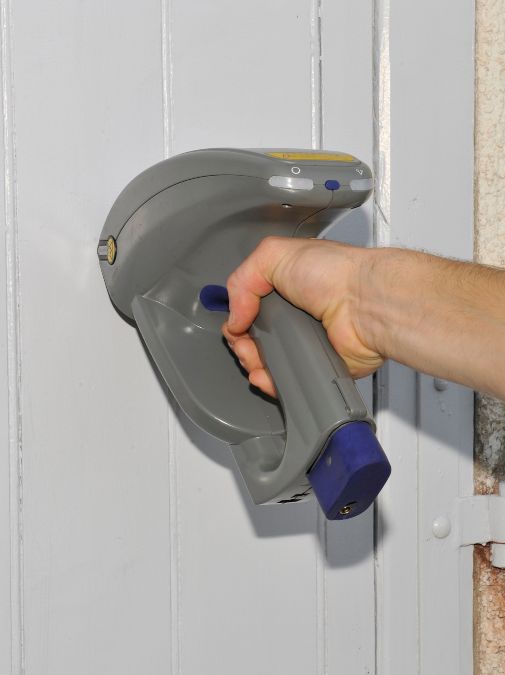 Technicien en gants utilisant un appareil de mesure électrique sur un tableau de contrôle